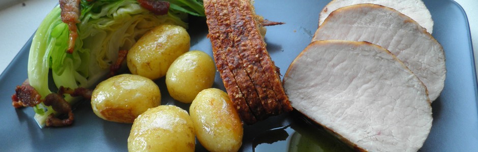 Flæskesteg med sprød svær, spidskål og nye kartofler i det nye nordiske køkken