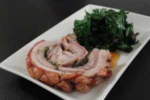 Mini porchetta fyldt med rosmarin og bacon og med flæskesvær hele vejen rundt. Serveret med appelsin sauce og stegt grønkål.